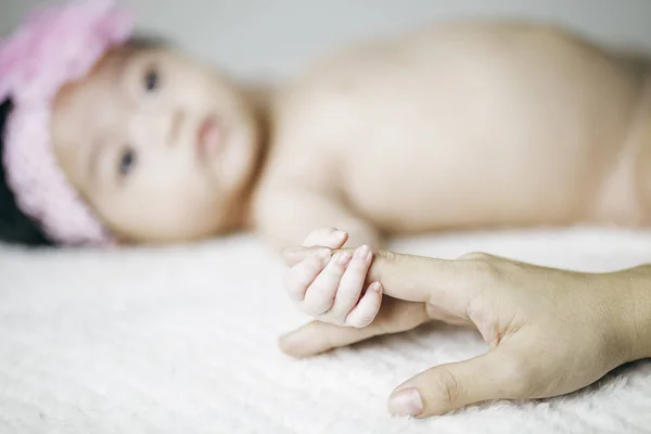 Noworodka trzyma palec jej matka — Zdjęcie stockowe