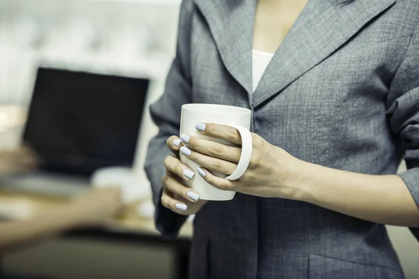 Nahaufnahme einer Kaffeetasse, die von einer Frau gehalten wird — Stockfoto