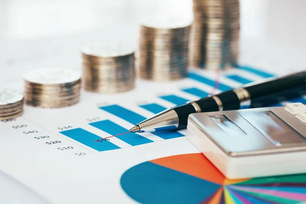 Financial chart with coins, pen and calculator — Stock Photo, Image