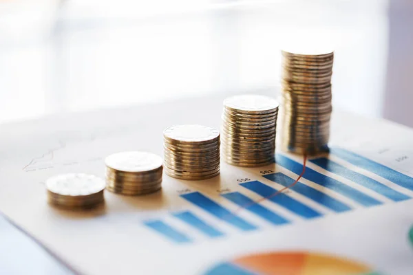 Stack of coins in a row on business chart — Stock Photo, Image