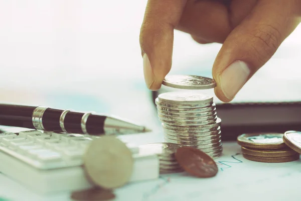 Mão colocando moeda na pilha de moedas — Fotografia de Stock