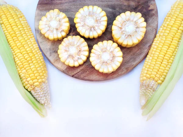 Kukuřice s prkénko na bílém pozadí — Stock fotografie