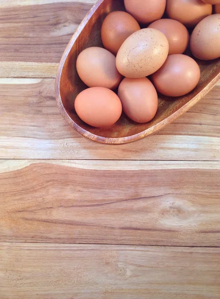 Αυγά σε ξύλινο μπολ σε φόντο ξύλινη — Φωτογραφία Αρχείου