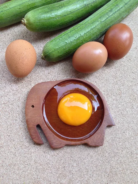 Яйце жовтого кольору на дерев'яній тарілці у формі слона з яйцями та кутом — стокове фото