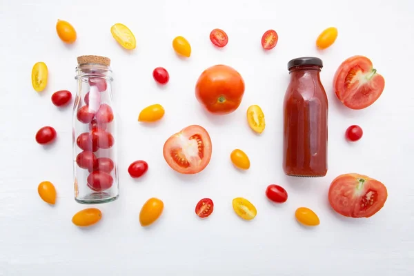 Tomatensaft in der Flasche und frische Tomaten auf weißem Holzrücken — Stockfoto