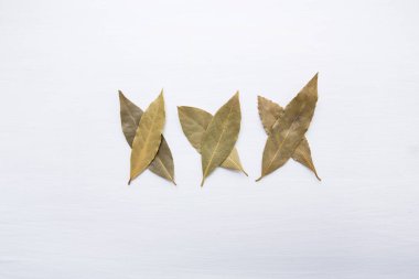 Beyaz ahşap zemin üzerinde kurutulmuş defne yaprağı.