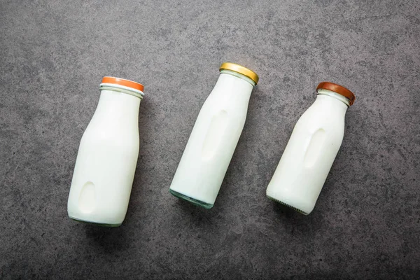 Botella de leche sobre fondo de piedra oscura. Vista superior con espacio de copia . — Foto de Stock
