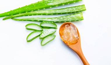 Aloe vera üzerinde izole kahverengi tahta kaşık üzerinde beyaz backgro dilimlenmiş
