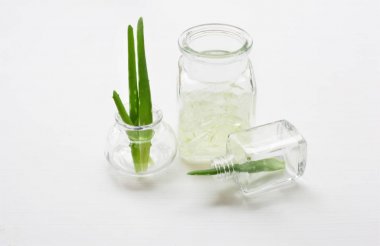 Aloe vera jel ve Aloe Vera yaprağı üzerinde izole küçük şişede 