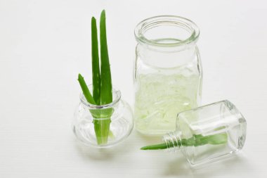 Aloe vera jel ve Aloe Vera yaprağı üzerinde izole küçük şişede 