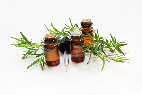 Rosemary essential oil with fresh leaves.