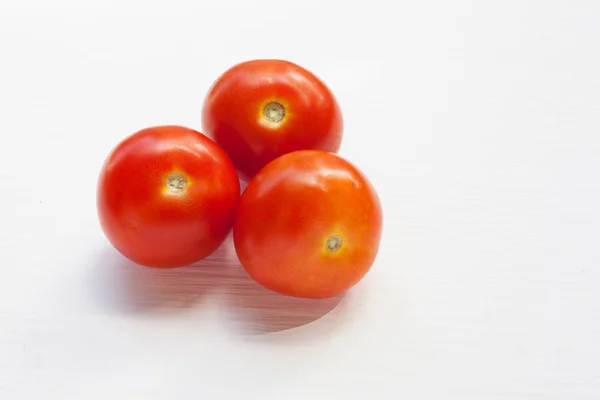 Drei rote Tomaten auf einem weißen . — Stockfoto