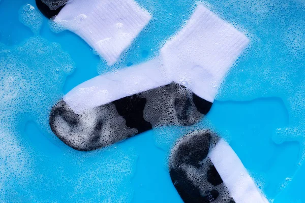 Dirty socks soaking in powder detergent water dissolution.