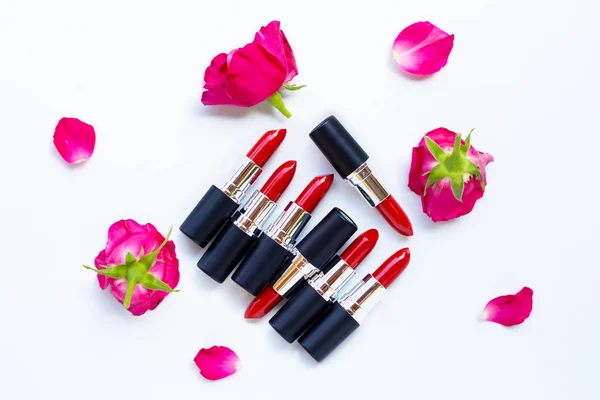 Lippenstifte mit Rosenblüte auf Weiß. Schönes Make-up-Konzept — Stockfoto