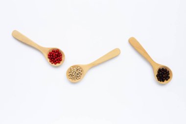 Kırmızı, beyaz ve siyah biberli. Beyaz üzerine tahta kaşık..