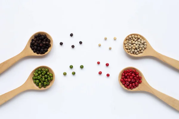 Peppercorns verdes, rojos, blancos y negros con cuchara de madera en whi — Foto de Stock