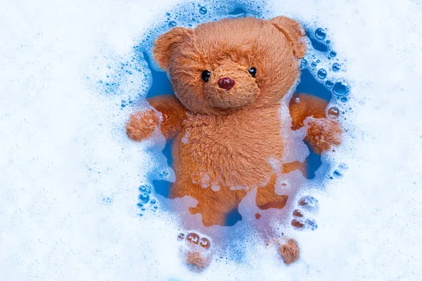 Замачивание игрушечного медведя в растворе моющего средства раньше было — стоковое фото