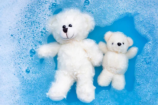 Mergulhe ursos de brinquedo na dissolução de água detergente lavanderia antes foi — Fotografia de Stock