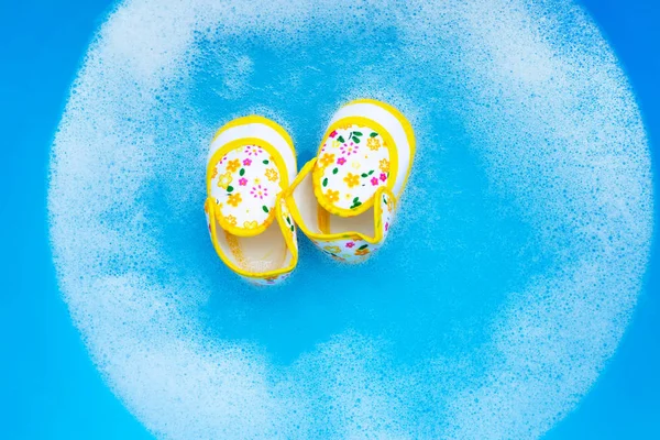 Remoje los zapatos del bebé en la disolución del agua del detergente de ropa del bebé befo — Foto de Stock
