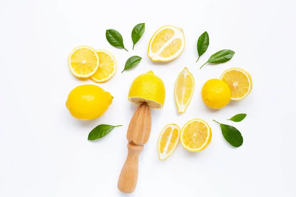 Limón fresco y hojas con exprimidor de madera sobre blanco — Foto de Stock