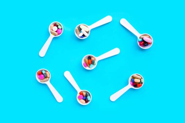 Mavi arka planda renkli ilaç hapları, haplar ve kapsüller