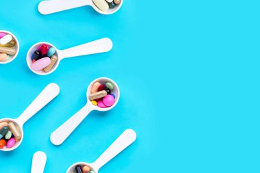 Mavi arka planda renkli ilaç hapları, haplar ve kapsüller