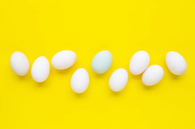 Sarı arka planda beyaz yumurtalar. Üstte görüntü