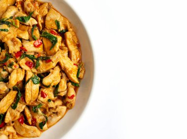 Beyaz arka plan üzerinde kutsal fesleğen ile tavada kızarmış tavuk.