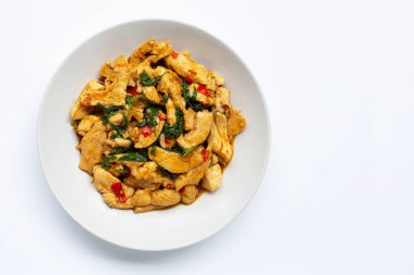 Beyaz arka plan üzerinde kutsal fesleğen ile tavada kızarmış tavuk.