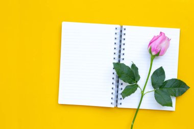 Sarı arka planda gül olan günlük defteri. Boşluğu kopyala