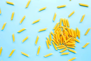 Pişmemiş makarna mavi arka planda izole edilmiş. Üst görünüm