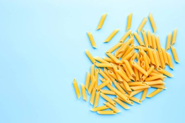 Pişmemiş makarna mavi arka planda izole edilmiş. Boşluğu kopyala