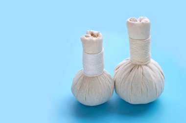Tayland masajı ve mavi arka planda kaplıca tedavisi için bitkisel kompres topları. Boşluğu kopyala