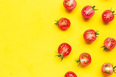 Taze vişneli domates, sarı arka planda yarı kesik. Boşluğu kopyala