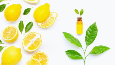 Beyaz arka planda limon ve turunçgil yeşili yapraklı doğal yağ. Yüksek C vitamini.