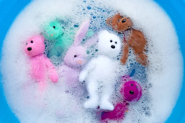 Yıkanmadan Önce Çamaşır Deterjanı Içinde Ayı Oyuncakları Olan Islak Tavşan — Stok fotoğraf