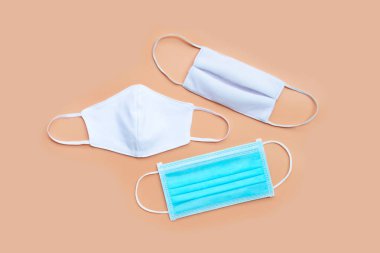 Krem rengi arka planda bez maskeli koruyucu tıbbi maske. Üst görünüm