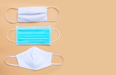 Krem rengi arka planda bez maskeli koruyucu tıbbi maske. Boşluğu kopyala