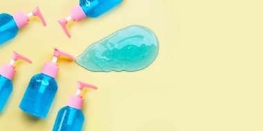 Sarı arka planda pompa şişesinde alkol el dezenfektanı jeli. Boşluğu kopyala