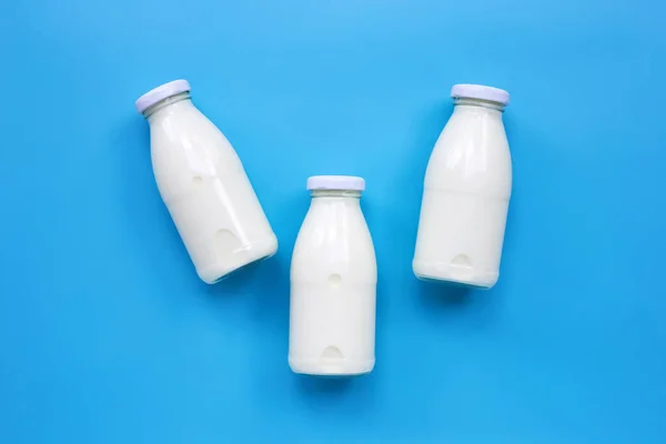 Mjölkflaskor Blå Bakgrund Kopiera Utrymme — Stockfoto