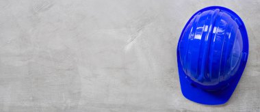 Beton arka planda inşaat miğferi. Boşluğu kopyala