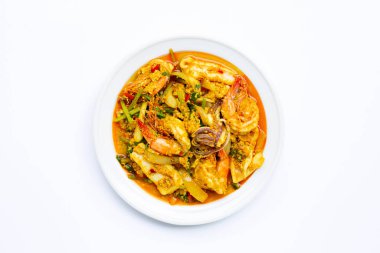 Beyaz zemin üzerinde köri tozu olan kızarmış deniz ürünleri..