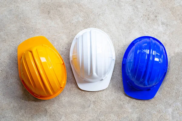 Construction helmets on concrete background. Top view