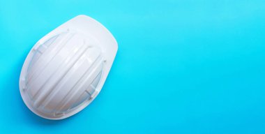 Mavi arka planda inşaat miğferi. Boşluğu kopyala