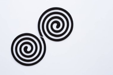 Black spiral mosquito repellent coils on white background. Copy space clipart