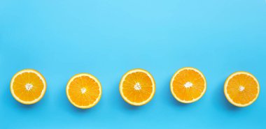 Yüksek C vitamini, sulu ve tatlı. Mavi arka planda taze portakal meyvesi. Üst görünüm