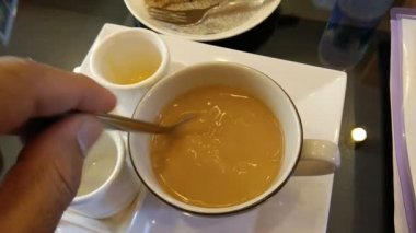 El beyaz bir fincan kahve kıpırdanırken.