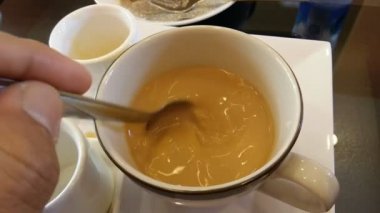 El beyaz bir fincan kahve kıpırdanırken.