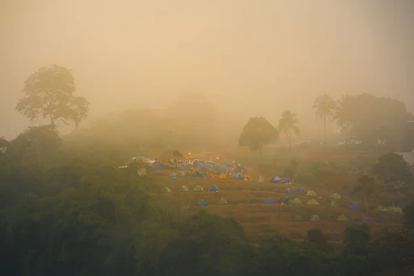 Ponto de vista de nuvens e tendas em uma colina ao nascer do sol — Fotografia de Stock