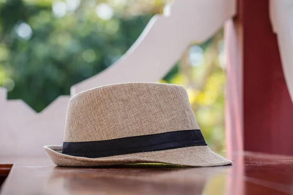 Pretty straw hat  on table background